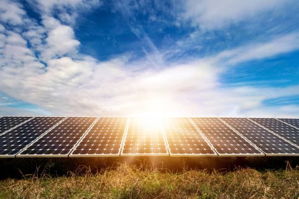 A photovoltaic solar panel in a field with blue sky 