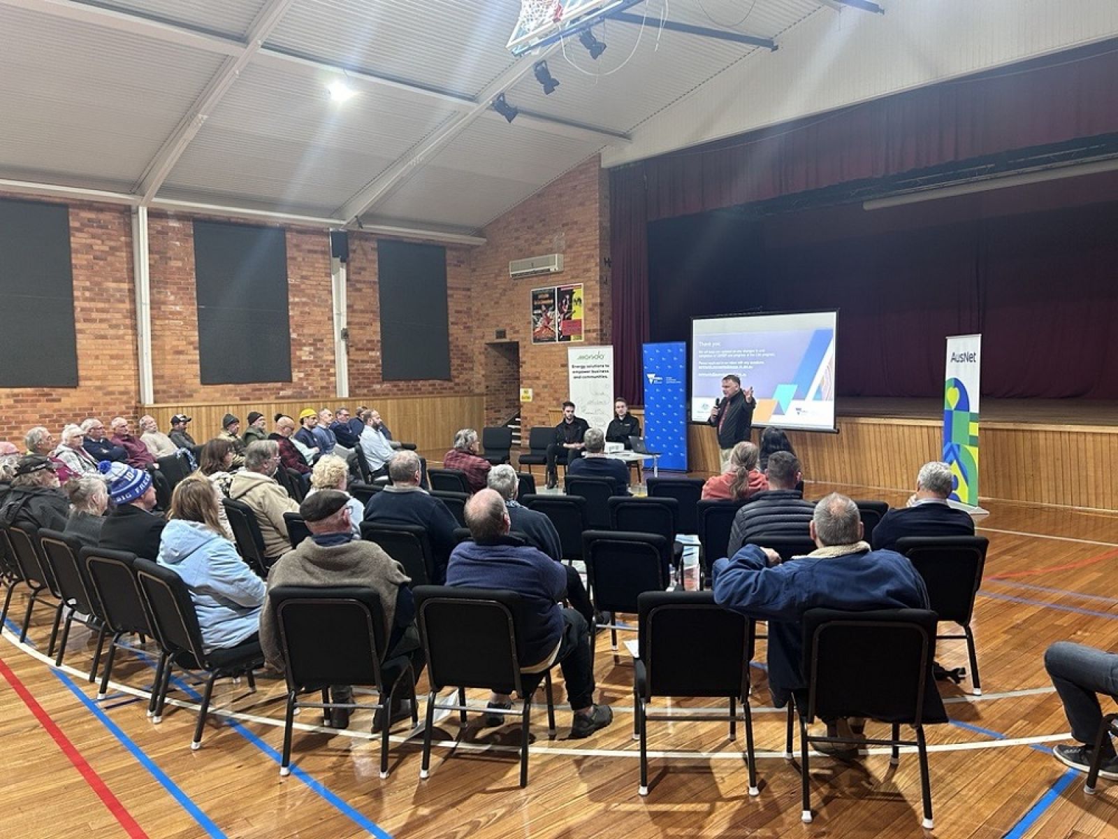 Man addresses hall of seated community in Corryong
