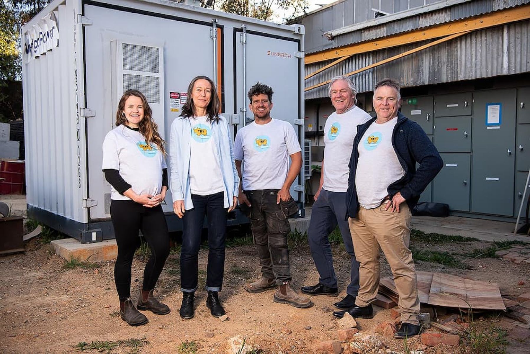 Picutre of members of the Totally Renewable Yackandandah standing in front of the Yackandandah battery. 