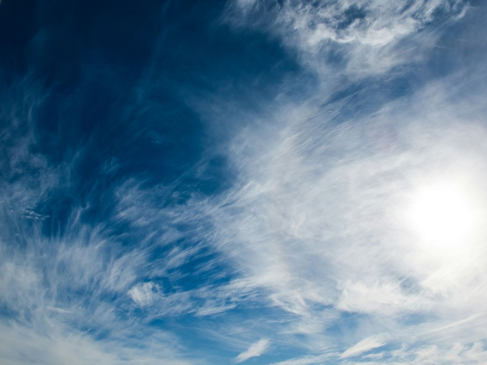 Blue sky with thin smattering of clouds